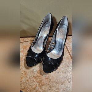 Black peep-toe heels with a glossy finish and medium to high heel